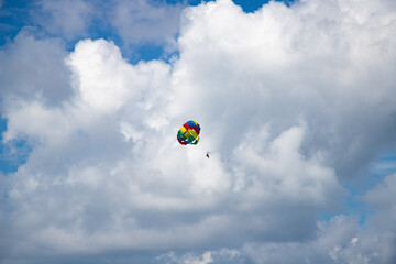 parasailing against blue sky rainbow colors