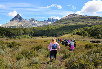 A group of tourists hike through the peat bogs of Tierra Del Fuego National Park at the southern...