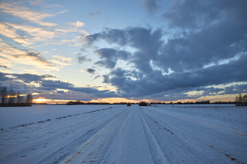 Sunset on a country snowy road. Ofroad road. Off-road at sunset.