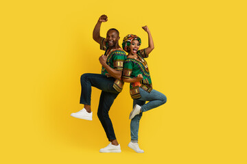Fototapeta na wymiar Positive happy black lovers celebrating success on yellow, gesturing