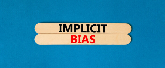 Implicit bias symbol. Concept words Implicit bias on wooden sticks. Beautiful blue table blue...