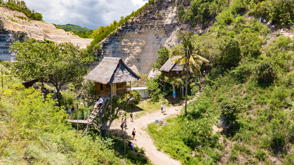 NUSA PENIDA, INDONESIA - NOVEMBER 8, 2022: Aerial view from drone of Tree House (Rumah Pohon) with croud of tourists waiting to shooting on stairs