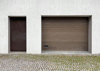 Entrance door and garage doors in a private house. Facade of the house. Modern garage