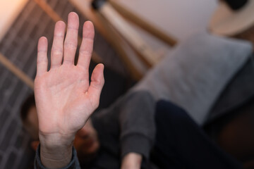 jeune homme accroupis victime de harcèlement se protégeant de sa main