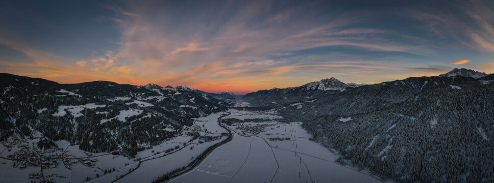 Sunset panoramic view of the top of Waidegg near Tressdorf on the border between Italy and Austria. Nassfeld ski resort in 5km. January 2022, drone aerial shot.