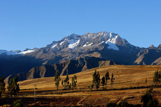 Mount Chicon Behind a Green Meadow and Under a Blue Sky. Urubamba Mountain Range, Cusco Region, Peru