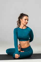 Fototapeta premium A beautiful woman is exercising in a yoga class for weight loss