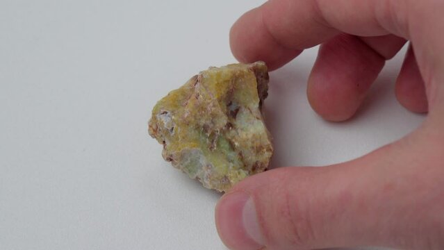 Rough yelow opal crystal, unpolished mineral. Close-up, white background