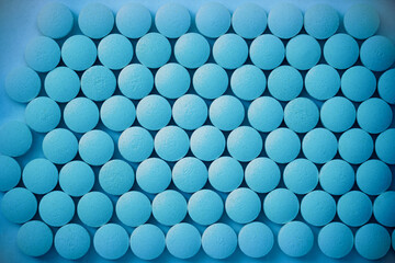 Round blue pills on a flat surface - Potency pharmacology
