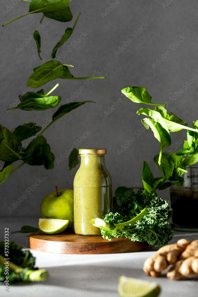 Wall mural Green smoothies concept with flying leaves of spinach around the bottle with ready to drink raw and healthy ingredients blend