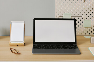 Open laptop with white screen mockup on desk at workplace