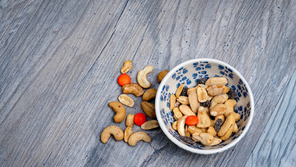 Fancy bowl filled with nuts on an old tabletop