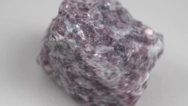 Lepidolite stone on a black background, being a secondary source of lithium, used in batteries