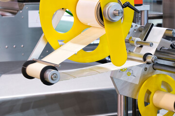 Fragment of the conveyor of sticking labeling machine. Abstract industrial background.