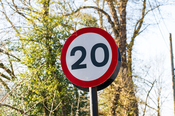 UK Traffic sign showing.a 20 mph maximum speed limit with a red and white warning circle