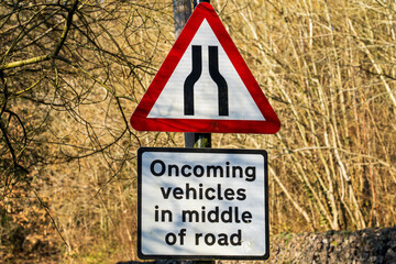 UK Traffic sign stating road narrows ahead and oncoming wehicles will be in the middle of the road...