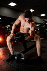 Fototapeta na wymiar Muscular young man training in gym. Athletic shirtless bodybuilder.