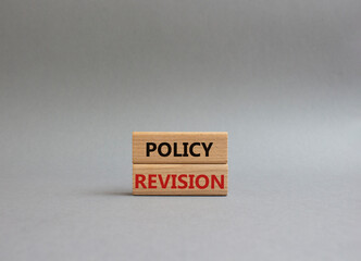 Policy revision symbol. Concept word Policy revision on wooden blocks. Beautiful grey background....