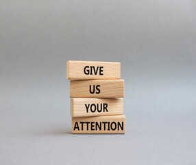 Attention symbol. Concept word Give us your attention on wooden blocks. Beautiful grey background. Business and Give us your attention concept. Copy space