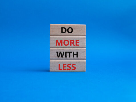 Do more with less symbol. Concept words Do more with less on wooden blocks. Beautiful blue background. Business and Do more with less concept. Copy space.