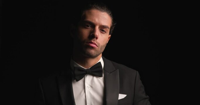 businessman arranging his tux and bowtie and asking us to follow him