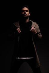 guy arranging his coat with tough attitude