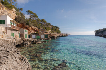 Cala Llombards (Mallorca, Balearic Islands, Spain). A cove with crystal clear turquoise waters, houses with jetties and a fine sandy beach.
