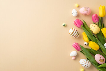 Easter celebration concept. Top view photo of colorful easter eggs yellow and pink tulips on isolated pastel beige background with copyspace