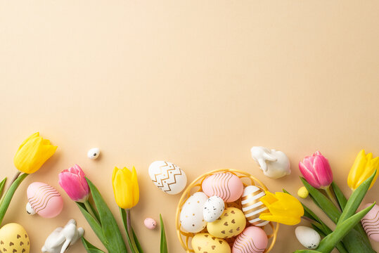 Easter celebration concept. Top view photo of colorful easter eggs in bowl ceramic bunnies yellow and pink tulips on isolated pastel beige background with copyspace