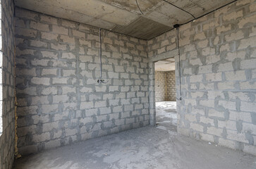 Construction of an individual residential building, view of the corner of the room, one of the walls with a doorway