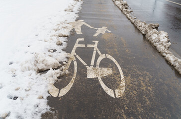 A bicycle sign on the road on a snowy winter day.