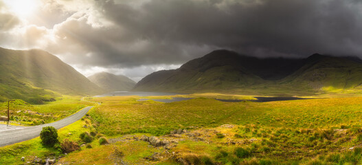 Panorama of Doolough Valley with lakes, Glenummera and Glencullin mountain ranges illuminated by...