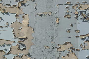 Old blue peeling paint on a wall, textured background