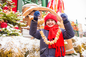  smiling boy at the traditional Russian festival dedicated to the meeting of spring, the week of pancakes, Shrovetide. the child stands at the decorations for the Maslenitsa holiday
