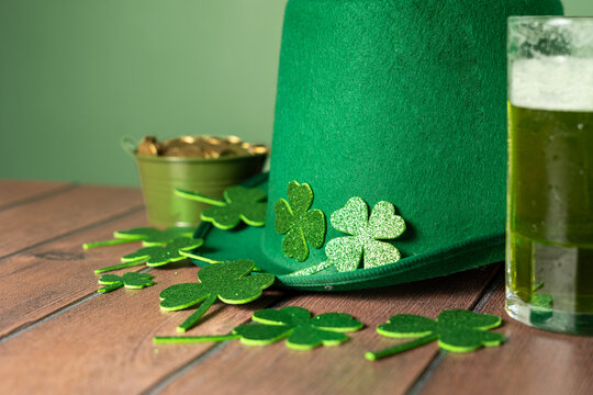 St. Patrick's Day: A green hat, shamrocks, coins and a mug of beer on the table. High quality photo