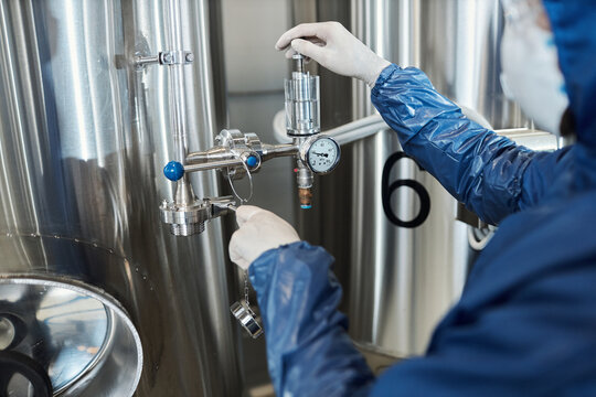 Close up of worker wearing protective suit working with equipment