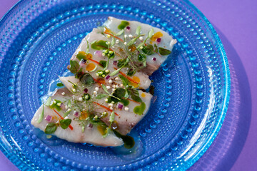 Restaurant food. Fish Hamachi with, yuzu, purple onion, chilli, coriander. Top view of Japanese food Trend colours.