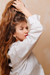 a woman in a in a white shirt corrects the hairstyle