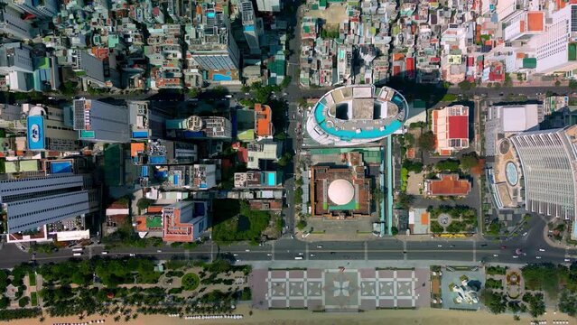 Aerial Birds Eye Overhead Top of Nha Trang street with skyscrapers of Vietnam, urban buildings street in Vietnam with busy car traffic.Vietnam city view from above. Drone flying over the coastal city.