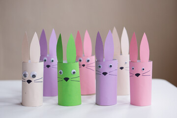 A banner from handmade easter bunny toy gift on a white table background. Paper easter rabbits. Happy easter.