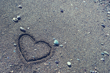 Fototapeta na wymiar Drawing of a heart on the sand at the sea beach, copy space. Romantic background