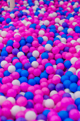 Background, texture of many colored, multi-colored round plastic small balls on the playground for children's games. Photography, top view, copy space, childhood concept, macro.