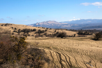 Idyllic mountain landscape, with the peaks covered with snow, early spring. Family travel by car to the picturesque mountains in early spring.