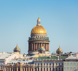 The urban landscape of St. Petersburg with a view of St. Isaac's Cathedral with a brilliant dome against the blue sky, view from the University embankment.