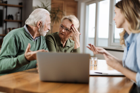 Worried senior couple having a meeting with their insurance agent at home