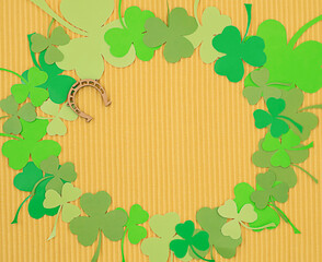 The concept of St. Patrick's Day. A green shamrock layout on a yellow background with a wooden...