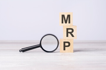 concept Marketing Research Planning or MRP. text on wooden cubes under a magnifying glass.