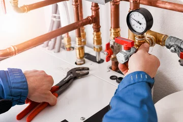 Plumbing concept or service worker. Copper pipelines close up with analog pressure gauge. © Milan
