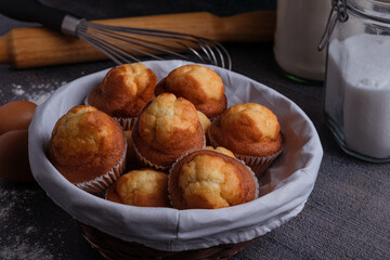 Wicker basket with cupcakes and kitchen utensils