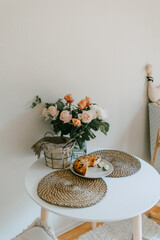 White round table with bunch of beautiful roses on it, home interior